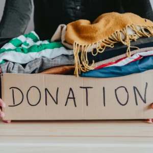 Box of clothes labeled "Donation" being held.