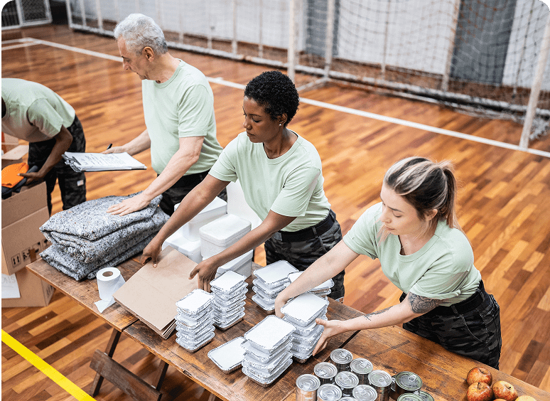 Volunteers packing food and supplies indoors.