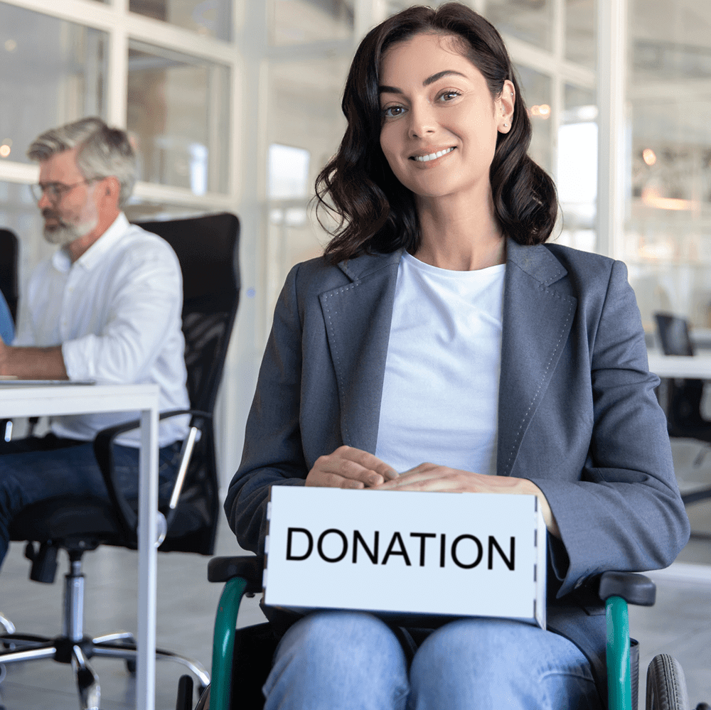 A woman holding a donation box and smiling in an office.