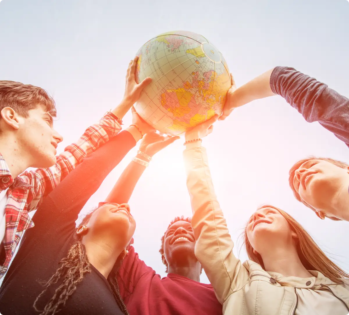 Diverse group holding up a globe together.
